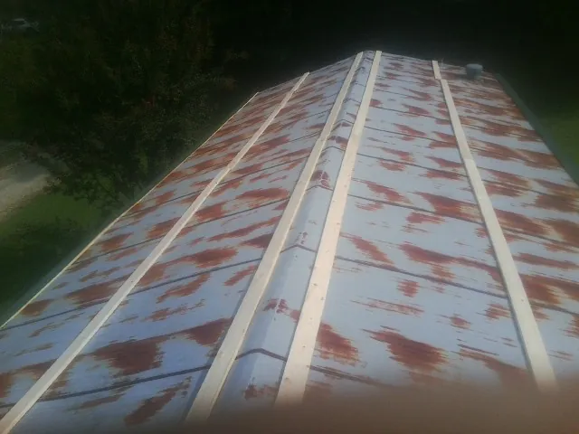 Rusted metal roof panels with new wood purlins before replacement — Storm Damage Roof Repair in Manson by Roofing Brothers